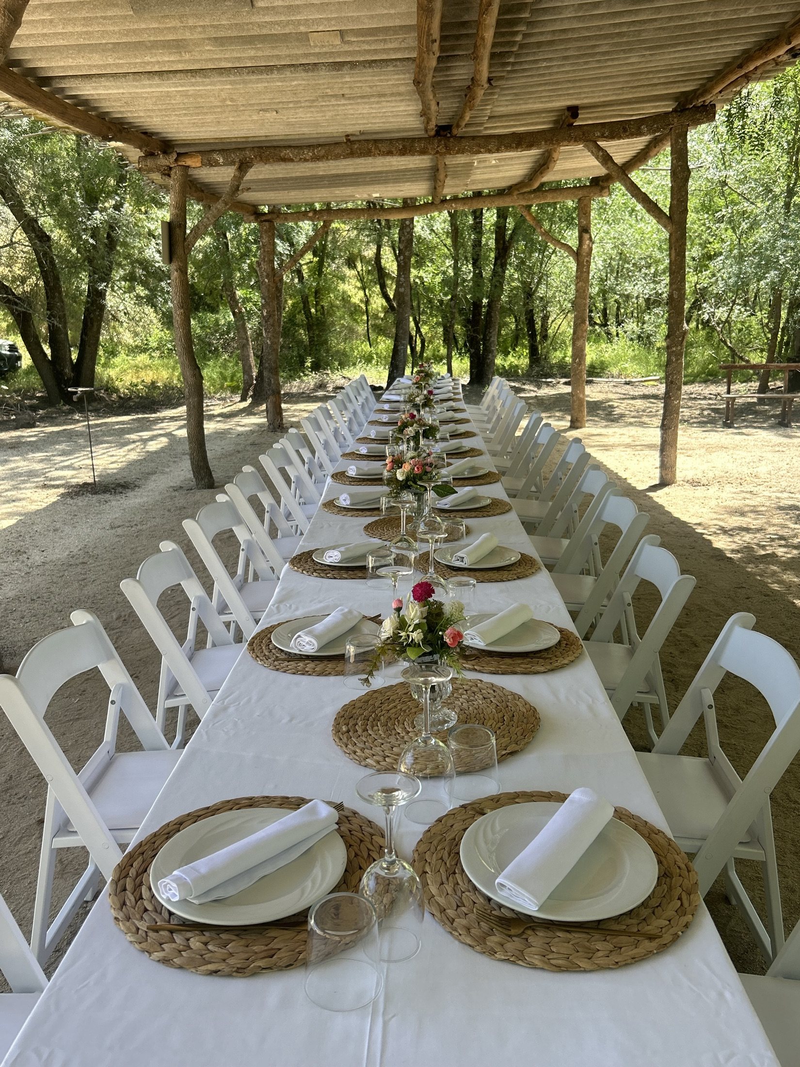 Mesa larga de hospitality real bajo sombra en La Ronca